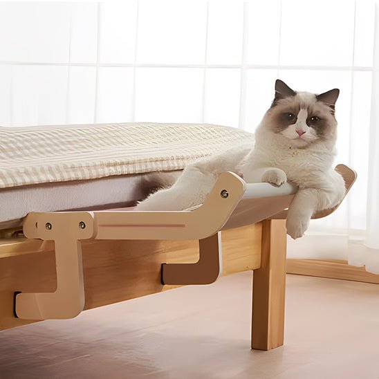 Hamac pour chat suspendu installé sur le bord d'un lit