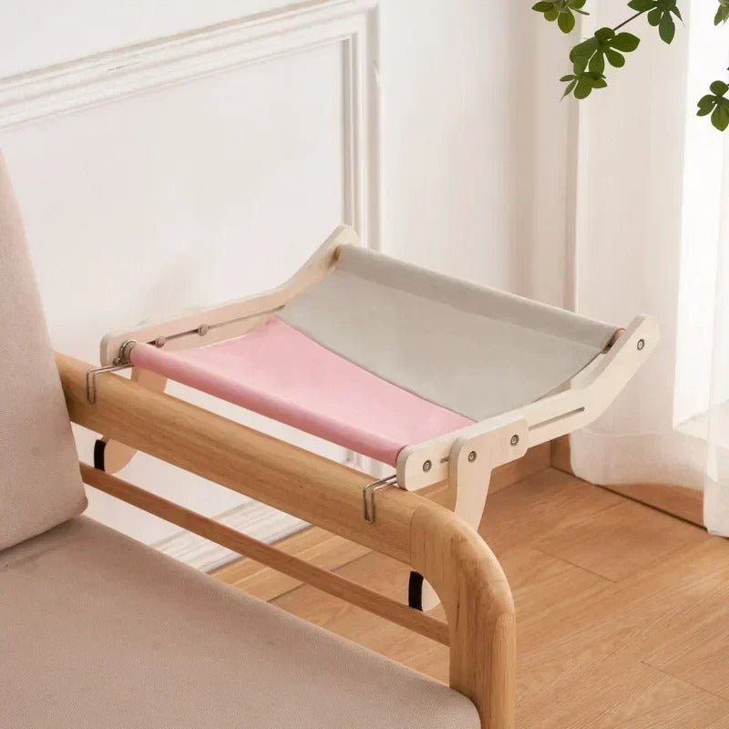 Hamac mural pour chat rose installé sur un meuble
